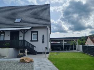 une maison blanche avec une cour et un bâtiment dans l'établissement Gästehaus Nebenan, à Dahn