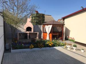 a backyard with a garden with flowers and a gazebo at Гостевой Дом ,Breeze in Chornomorsk
