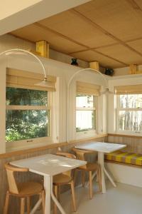 2 mesas y sillas en una cocina con ventanas en Hotel des Dunes, en Cap-Ferret