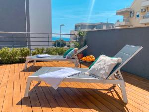 a balcony with two chairs and a bowl of fruit at AstraMaris Znjan - Deluxe beach suite with hot tub in Split