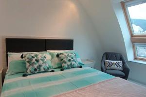 a bedroom with a large bed and a chair at LOFT PLAYA BURELA in Burela de Cabo