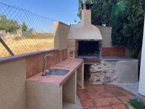 eine Außenküche mit einem Steinofen und einer Spüle in der Unterkunft Casa Rural Alquería de Segovia in Tizneros