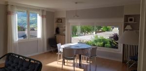 uma sala de jantar com uma mesa e uma grande janela em Montcalm em Millau