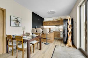 a kitchen and dining room with a table and chairs at THE ROOT your charming floating home in Bratislava