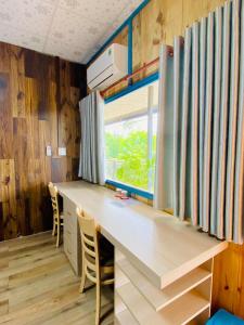einen Schreibtisch in einem winzigen Haus mit Fenster in der Unterkunft Bến Hồ Homestay in Xã Gia Tân