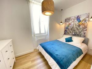 1 dormitorio con 1 cama y una pintura en la pared en 06AN - Bel appartement au cœur du Vieil Antibes, en Antibes