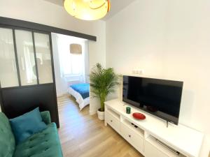 sala de estar con TV de pantalla plana y sofá en 06AN - Bel appartement au cœur du Vieil Antibes, en Antibes