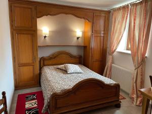 une chambre avec un lit en bois et une fenêtre dans l'établissement La Grange du Pape - Annexe de l'Hôtel La Ferme du Pape, à Eguisheim
