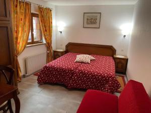 une chambre avec un lit avec une couette rouge dans l'établissement La Grange du Pape - Annexe de l'Hôtel La Ferme du Pape, à Eguisheim 9 autres photos