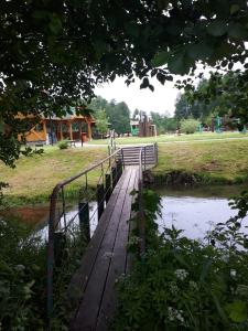 a bridge over a river with a playground in the background at Pokoje nad Szeszupą Jasionkove DOBRO in Rutka Tartak