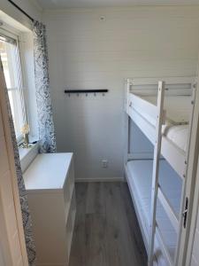 niewielka sypialnia z łóżkiem piętrowym i drabiną w obiekcie Kaptenhuset Skrea strand w mieście Falkenberg