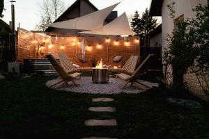 a backyard with chairs and a fire pit with lights at Tuyo Casa Sarabandy in Warsaw