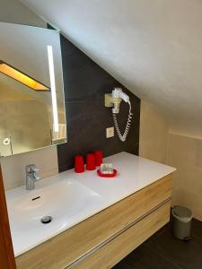 a bathroom with a sink with a phone on the wall at Hôtel Restaurant À la ville de Nancy in Eguisheim