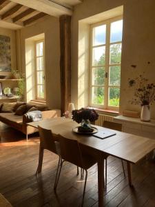 a living room with a table and a couch at Maison d'hôtes La Doucelle culture et bien-être in Lignieres-Orgeres
