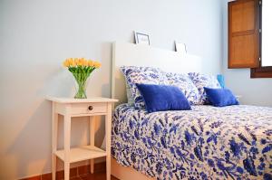1 dormitorio con 1 cama y un jarrón de flores sobre una mesa en la cotera vut, en Colombres