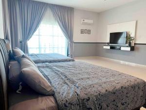 een slaapkamer met 2 bedden en een flatscreen-tv bij Sweet HOME FOR BIG Family｜11pax+FREE WIFI in Sitiawan
