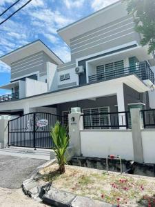 una casa blanca con una valla negra en Sweet HOME FOR BIG Family｜11pax+FREE WIFI, en Sitiawan