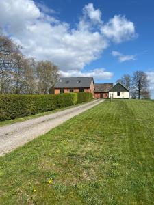 una casa en un campo con un camino de tierra en Annavälla gårdshus, en Skurup