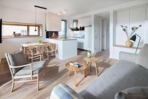 een woonkamer en een keuken met een bank en een tafel bij Dünenblick in Norderney