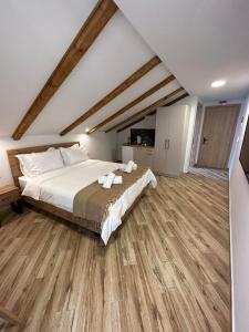 a bedroom with a large bed and wooden floors at Meteora Sunrise in Kalabaka