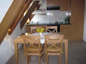 a kitchen with a wooden table and chairs in a kitchen at Landhaus Sorgenfrei in Hohnstein