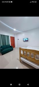 a living room with a bed and a couch at Kylitas transient house studio apartment 1st floor in Tagbilaran City