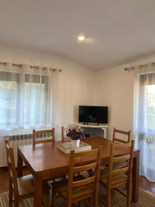 a dining room with a table and chairs and a television at Casa de Casarelhos - Vistas Serra do Gerês e rio - Lareira in Geres