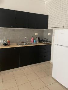 uma cozinha com armários pretos e um frigorífico branco em View of the Mediterranean Sea em Ashkelon