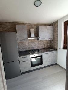 a kitchen with a stove and a refrigerator at The Sunrise in San Teodoro