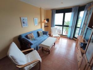 a living room with a blue couch and chairs at APARTAMENTO PLAYA CATEDRALES CON PISCINA Y TERRAZA in Barreiros