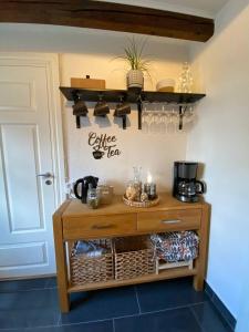 una cucina con tavolo in legno e tè e caffè di Annavälla gårdshus a Skurup