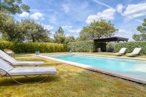 una piscina con 2 tumbonas junto a ella en Villa des Roses à Lorgues en Lorgues