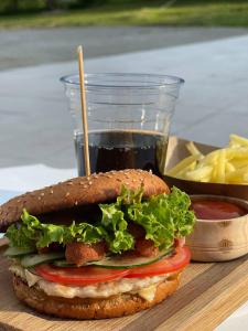 a sandwich with lettuce and tomato and a cup of ketchup at BAYKA - SPA resort in Kosiv