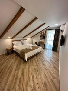 a bedroom with a large bed and wooden floors at Meteora Sunrise in Kalabaka