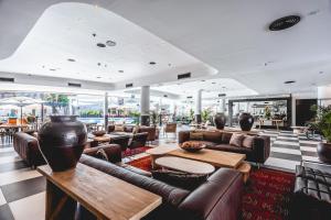 a lobby with couches and tables in a building at Jacob Eilat in Eilat