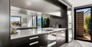 uma cozinha com electrodomésticos de aço inoxidável e uma grande janela em Magnificent View in Queenstown em Queenstown