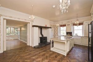 a large kitchen with a fireplace and a stove at Annsborough House Castlewellan in Castlewellan