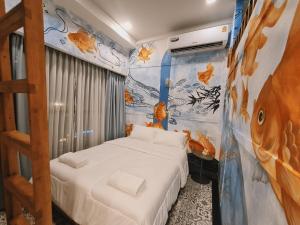 a bedroom with a bed and a mural of fish at Suraya Bangkok in Bangkok