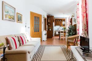 a living room with a couch and a kitchen at TRENTINO LODGE Via San Vito in Strigno