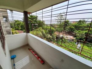 a room with a balcony with a large window with a view at Debjit Residency for Family only in Kolkata