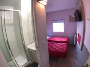 a small bathroom with a red stool and a sink at Premiere Classe Evry Sud - Mennecy in Ormoy