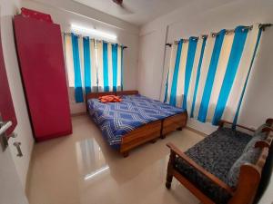 a bedroom with a bed and a chair in it at Debjit Residency for Family only in Kolkata