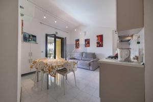 una cucina e un soggiorno con tavolo e sedie di La Palma - Immobiliare Azzurra a Lazise
