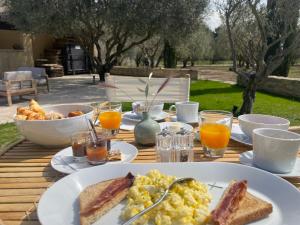 stół śniadaniowy z jajkami, tostami i sokiem pomarańczowym w obiekcie MAS MILLÉSIME - Chambre double - petit déjeuner - piscine - Mas du XVIIIème siècle proche Saint-Rémy-de-Provence w mieście Mas blanc des Alpilles