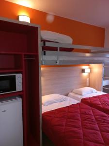 a bedroom with two bunk beds with red walls at Premiere Classe Evry Sud - Mennecy in Ormoy