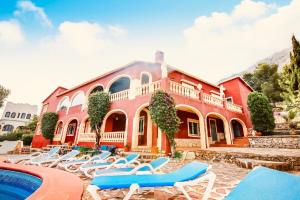 a building with lounge chairs and a swimming pool at PinkFlamingo in Denia