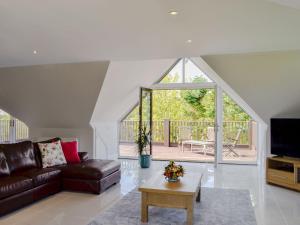 uma sala de estar com um sofá e uma mesa em Chestnut Lodge em Portpatrick