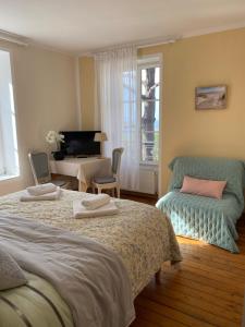 1 dormitorio con 2 camas, escritorio y TV en VILLA LA VISTULE en Dinard