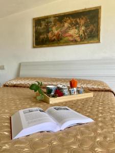 an open book on a bed with a tray of food at L'Olivo - 1932 in Controguerra
