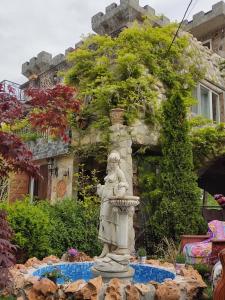 a statue of a woman in a fountain in a garden at Castel in Ciurbeşti